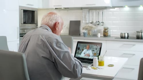 Senior Man Has Telehealth Appointment in Kitchen