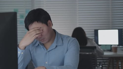 Tired Male Office Worker Sitting at desk concentrated on his work