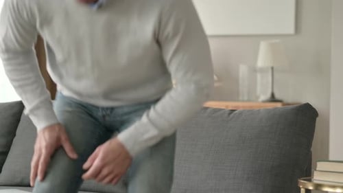 Man Sitting on Couch Opening Laptop and Typing