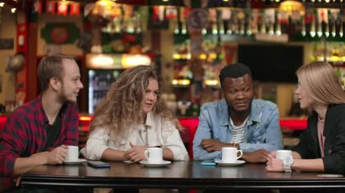 A Multinational Company of Friends Drinks Coffee and Talking in a Restaurant