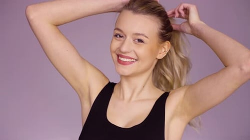 Smiling Woman Putting Her Hair in a Ponytail