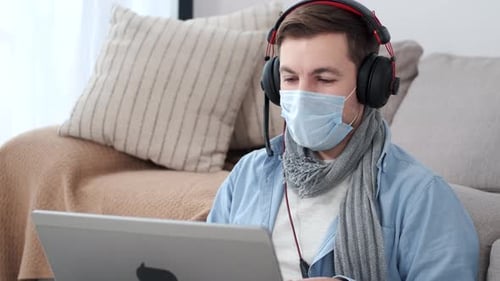 Young Adult Working from Home with Laptop and Mask