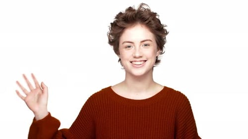 Retrato de uma mulher adulta amigável com um lindo penteado sorrindo para a câmera e recebendo com