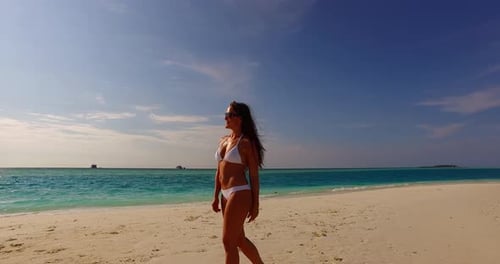 Young happy lady travelling having fun on the beach on clean white sand and blue 4K background