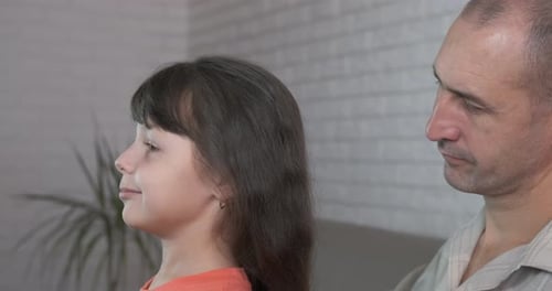 Affectionate Father Brushes Daughter's Hair at Home