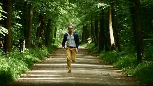 Junger kaukasischer Mann läuft auf Naturstraße im Freien