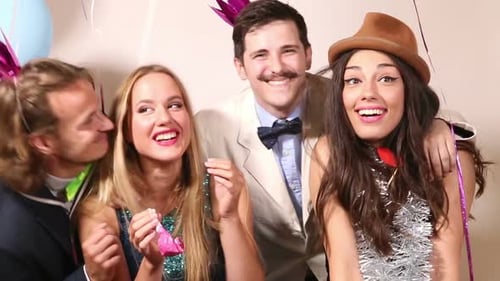 Two cute couples having fun in party photo booth