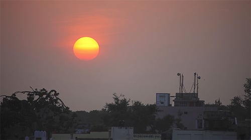 Sun Rising Over Silhouetted Buildings During Golden Hour