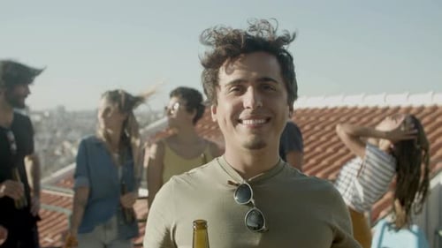 Smiling Man with Friends on Urban Rooftop