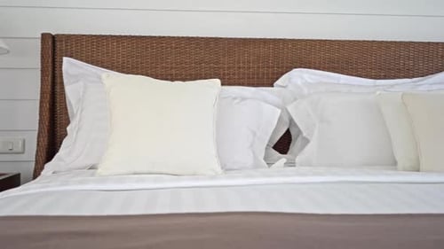 Clean White Bed with Woven Headboard in Bedroom