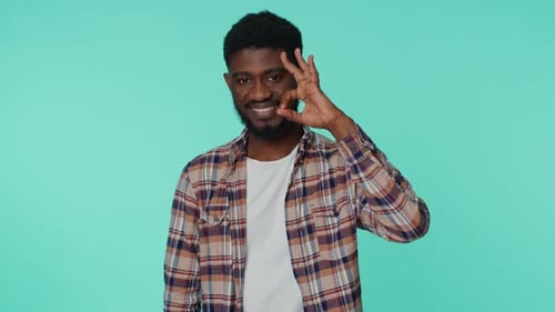 Man Gesturing Okay on Aquamarine Backdrop