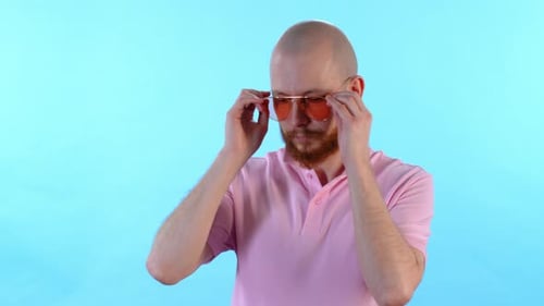 Man Puts on Sunglasses
