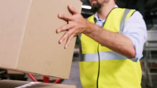 Worker pushing trolley of cardboard boxes