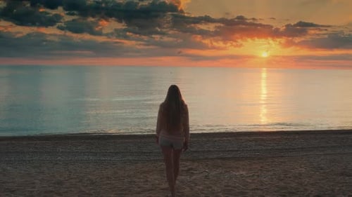 Woman with Long Hair Walking To the Sea and Raising Her Hands Up