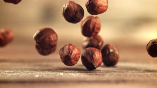 Hazelnuts Falling in Slow Motion on Wooden Table