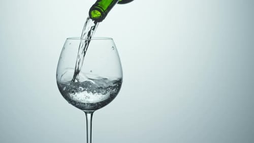 Selterswasser in Glas gießen