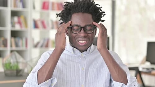 Young Adult Man Massaging Temples in Discomfort
