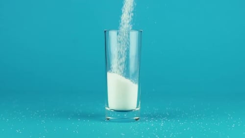 Powdered Sugar Being Poured Into a Glass