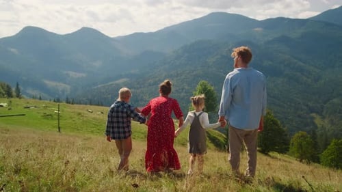 Family Walking Down Green Mountain Hill Back View