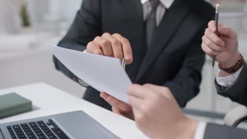 Adults Reviewing Business Documents in Office