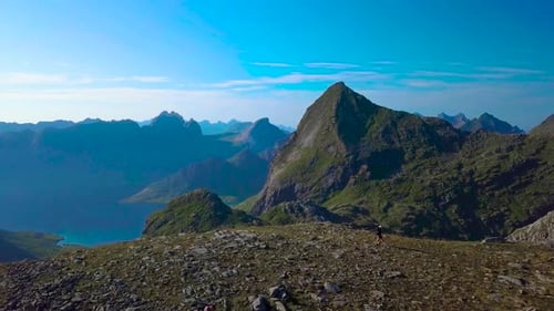 Aerial View of Girl with a Backpack Goes on a Mountain Ridge
