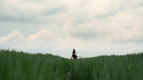 Girl In Black Dress Runs The Field. Romantic Image Of Blonde.
