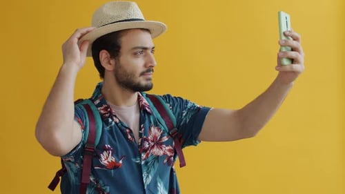 Young Adult Posing with Smartphone on Yellow Background