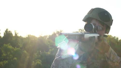 Young Adult Aims Rifle with Scope in Woods