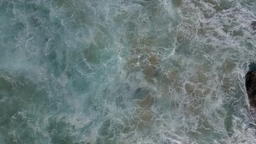 Aerial View of Waves Crashing on Rocks