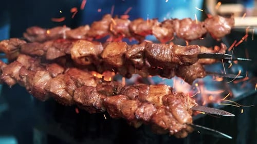 Cook making a barbecue on a grill at food festival