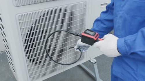 Technician Inspects Air Conditioner With Endoscopic Camera