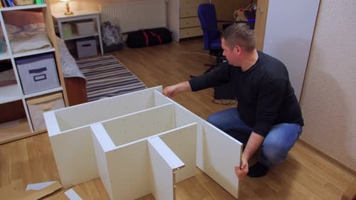 Man Assembling Shelving Unit in a Home
