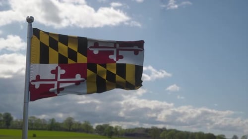 Realistic Waving Maryland State Flag Against Blue Sky