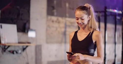 Beautiful Woman Using Smartphone At Gym