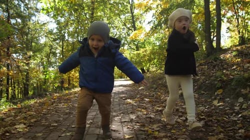 Happy Siblings Running Along Park Path During Play