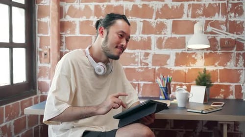 Man Smiles Using Tablet Device in Bright Room