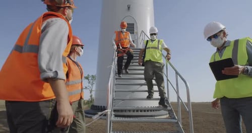 Engineers in Masks Walking Away Windmill