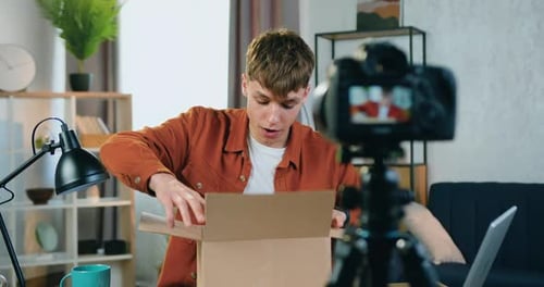 Young Man Unboxing Package for Video Blog