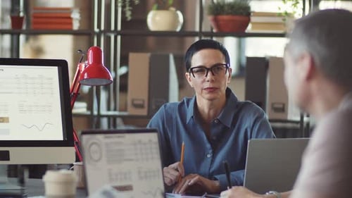 Woman Leads Business Meeting Analyzing Data