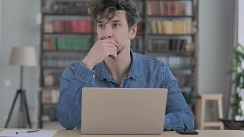 Pensive Man Thinking and Working on Laptop