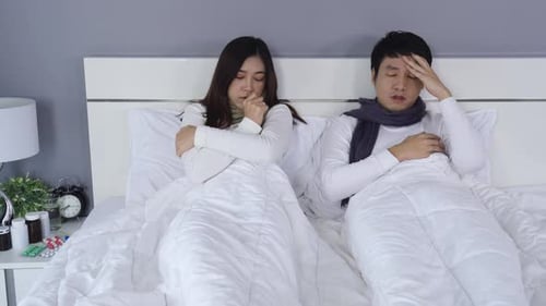 Shivering Couple Suffering Cold Lying in Bed