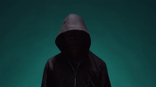 Shadowy Figure in Hood Making Stop Gesture