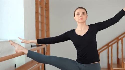 Young Sportive Woman Stretching Legs in a Gym