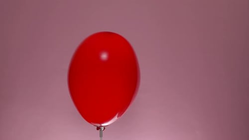 Red Heart Balloon Floating on Pink Background