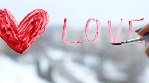 Painting "Love" on a Window in Winter