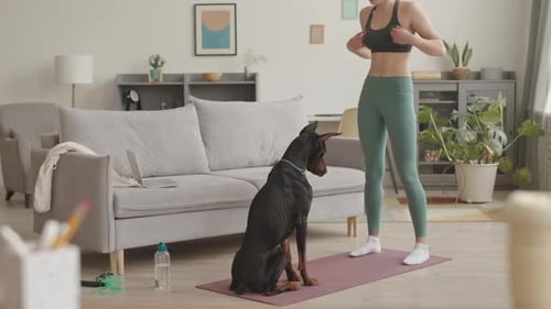 Woman Stretching with Doberman Dog on Yoga Mat