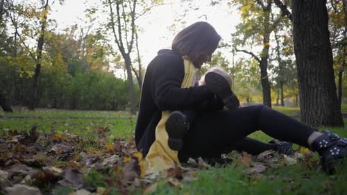 Mother and Child Laughing Together in Autumn Park