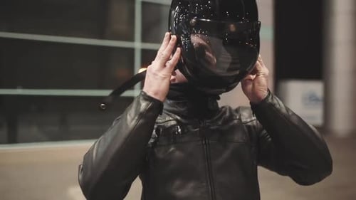 Caucasian Man Motorcyclist Wears a Helmet on Night Street