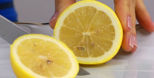 Woman Hand Cutting Lemon