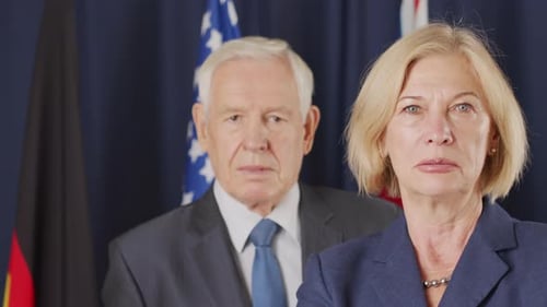 Serious Man and Woman Posing with Flags